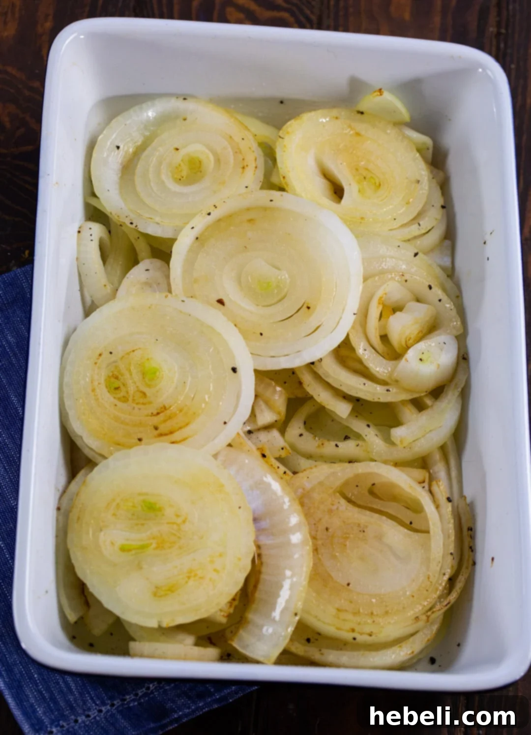 Sweet & Creamy Vidalia Gratin 5 Cooked Vidalia onion slices neatly arranged in a baking dish, forming the base of the au gratin.