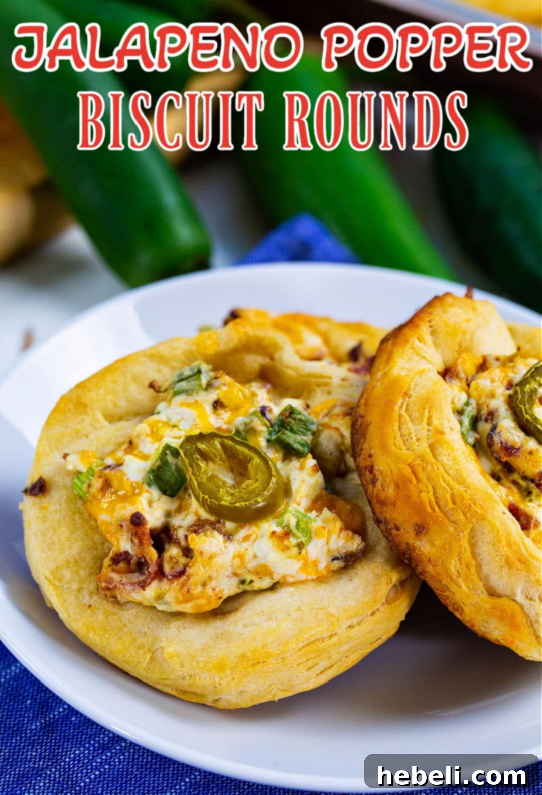 Several golden-brown Jalapeno Popper Biscuit Rounds arranged beautifully on a rustic white plate, garnished with fresh green onions.