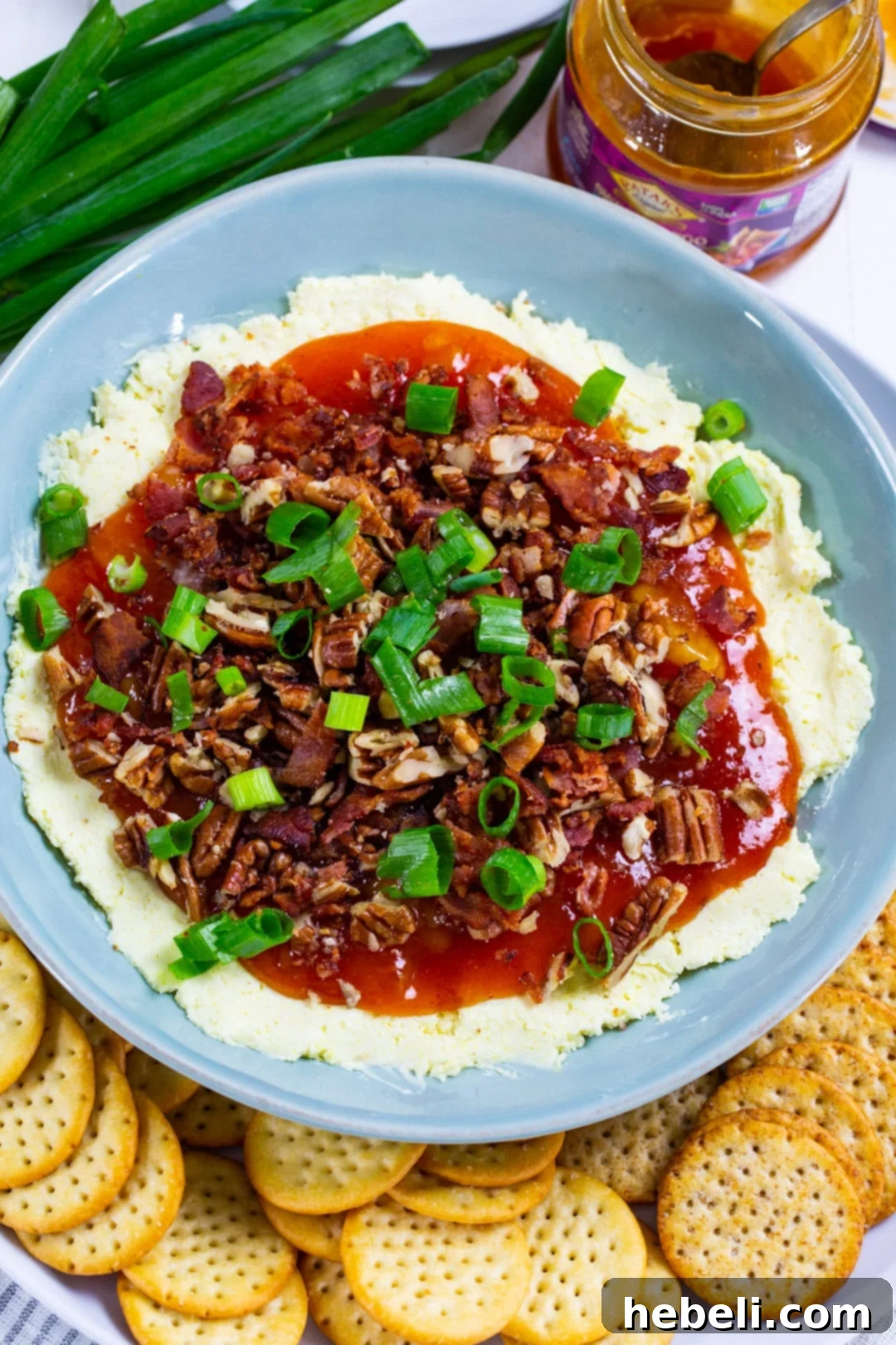 Tropical Tango Cheese Dip 3 Close-up shot of the layered Cheese Dip, showing the creamy white cheddar base and the rich orange mango chutney topping, surrounded by various crackers.