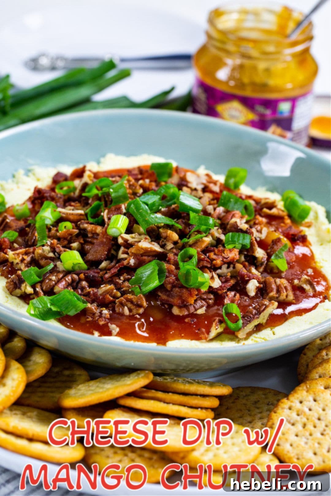 Tropical Tango Cheese Dip 4 A beautifully presented blue bowl of Cheese Dip with Mango Chutney, garnished and ready to be enjoyed, showcasing its rich texture and colorful topping.