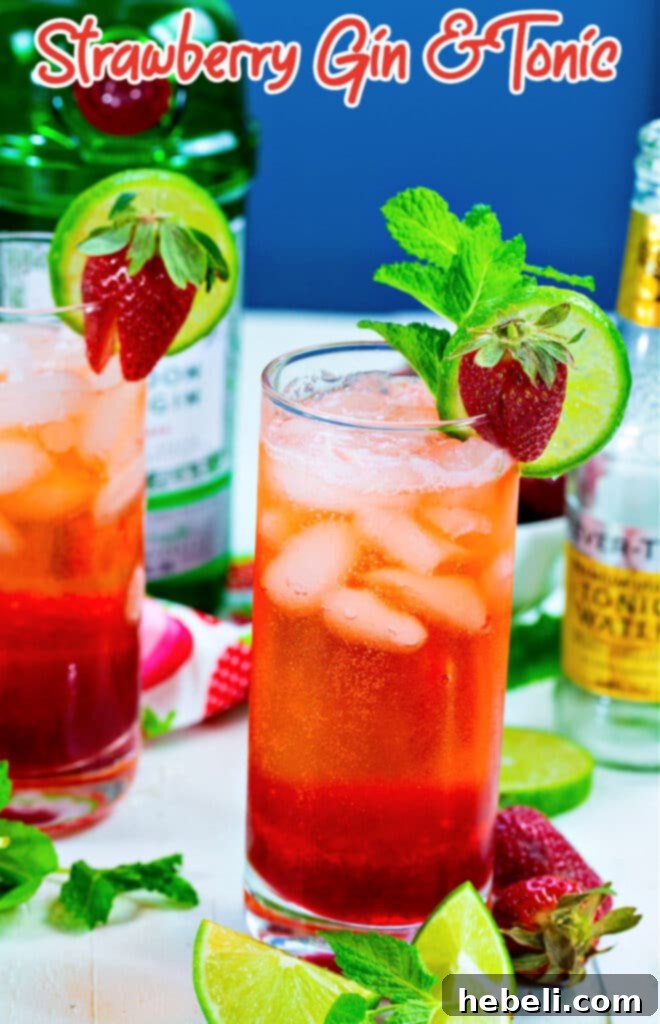 A perfectly prepared Strawberry Gin and Tonic, garnished with fresh strawberries and a lime slice, ready to be enjoyed.