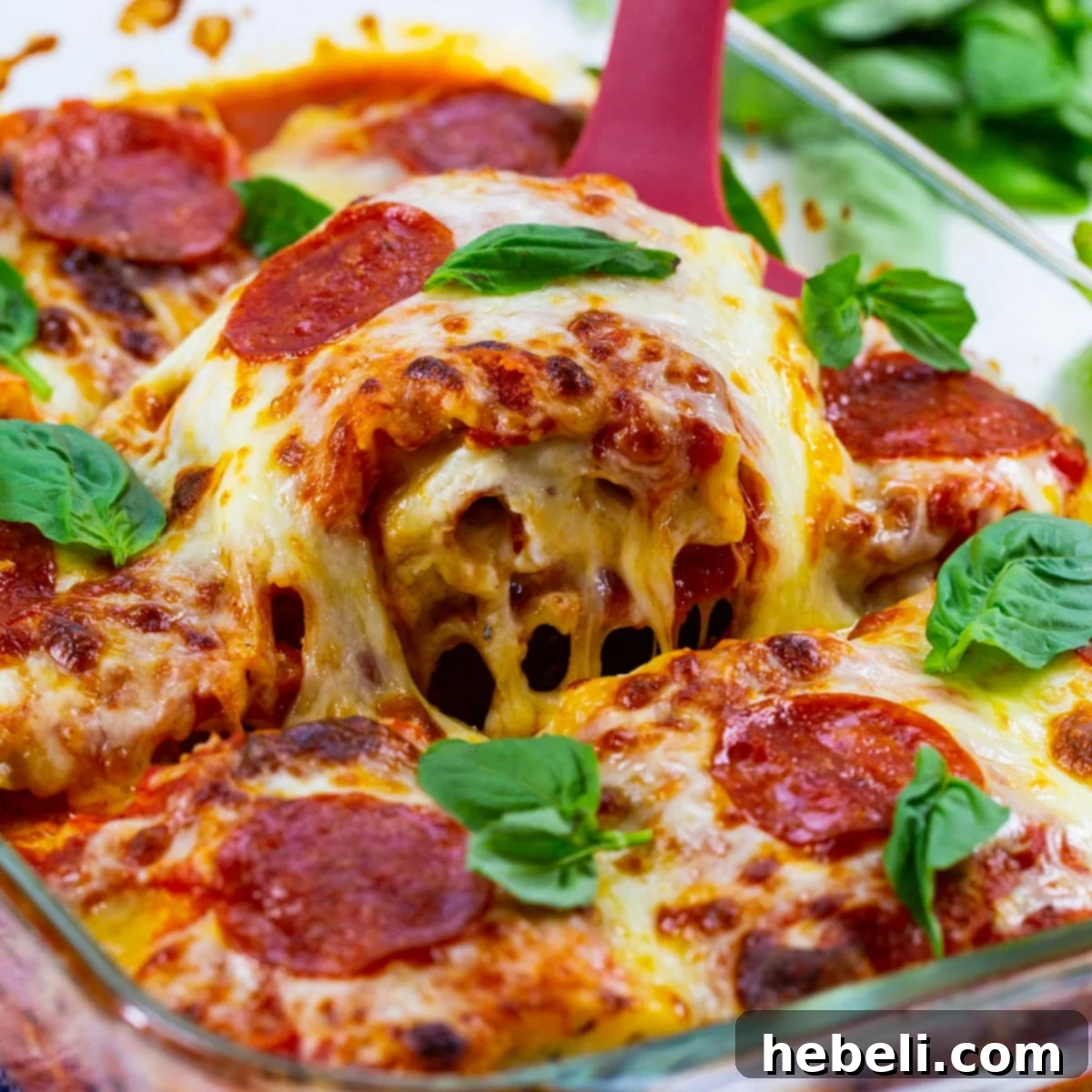 Spatula lifting Pepperoni Lasagna Roll-Ups out of pan.