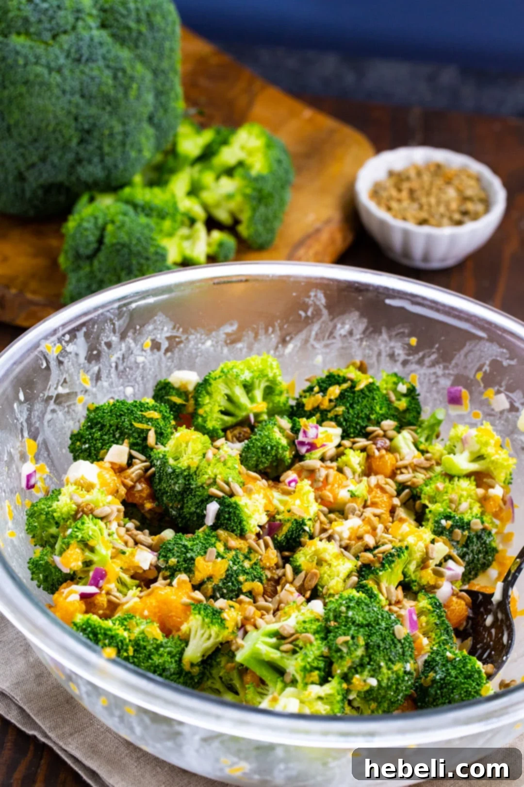 Zesty Orange Feta Broccoli Salad 3 Chopped broccoli florets and other salad ingredients being tossed in a large mixing bowl, before the dressing is added.