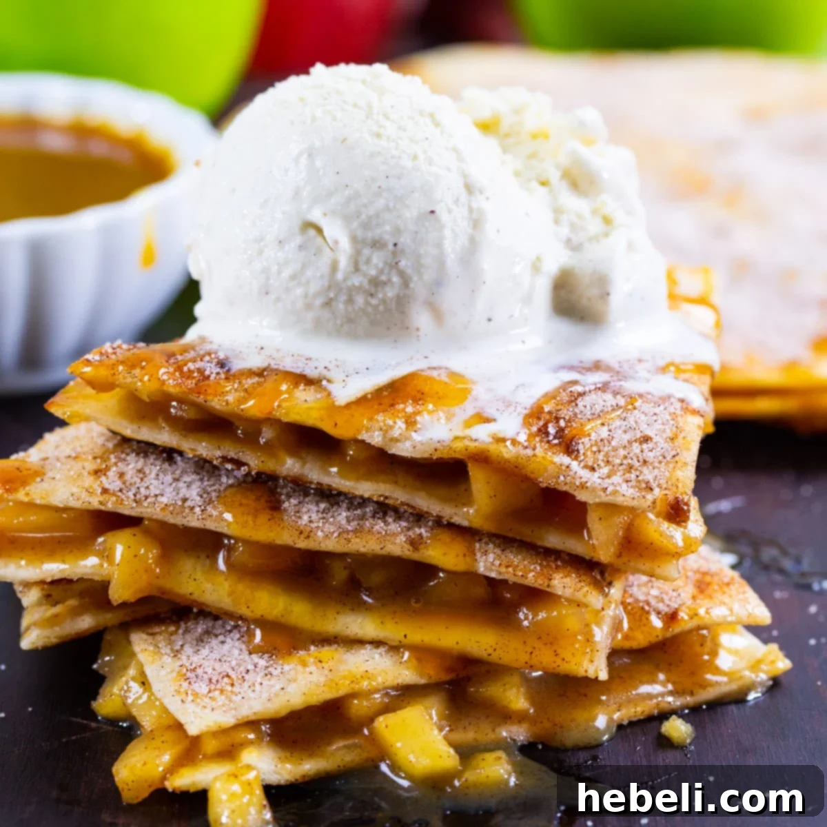 Close-up of Caramel Apple Quesadillas topped with melting vanilla ice cream and caramel drizzle.