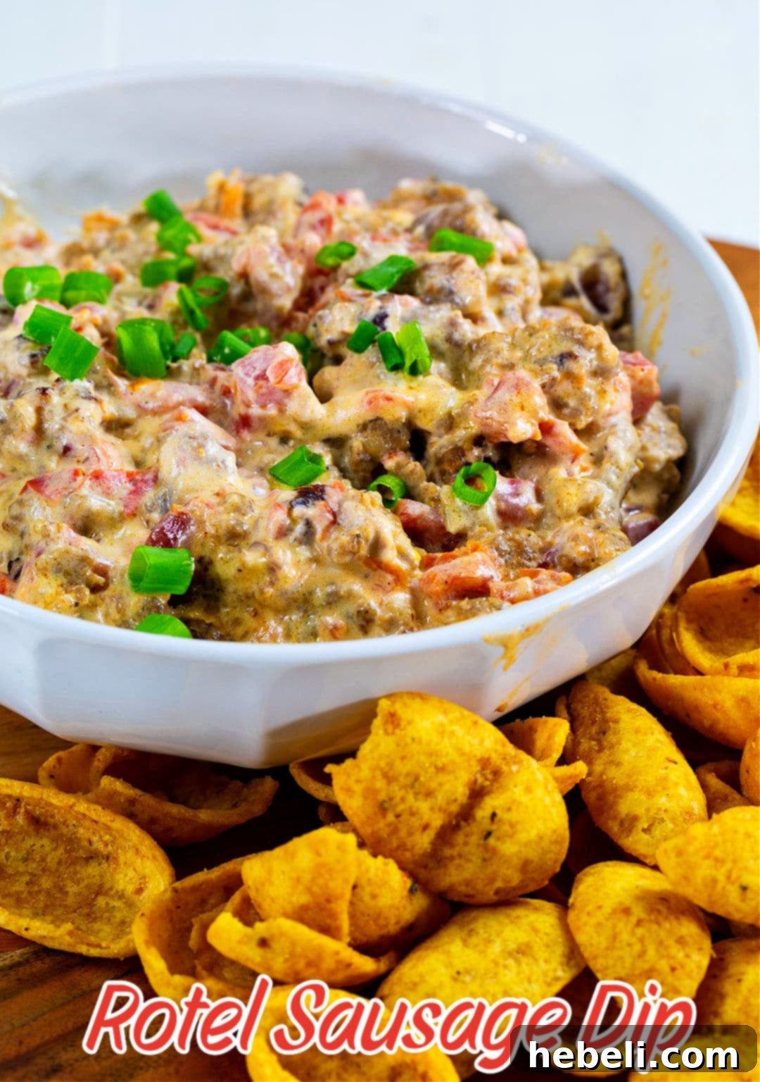 A generous bowl of creamy 3-Ingredient Rotel Sausage Dip, perfectly melted and ready to be enjoyed with surrounding Frito chips.