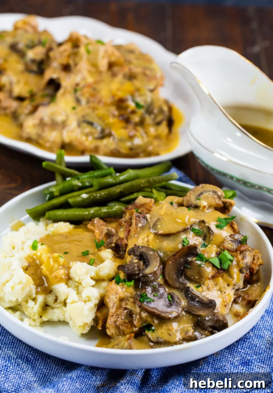 Mushroom and Onion Pork Chops on plate with mashed potatoes.
