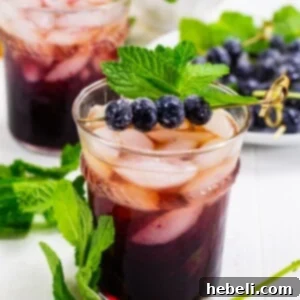 A beautifully crafted Blueberry Mint Julep, garnished with mint and sugared blueberries.