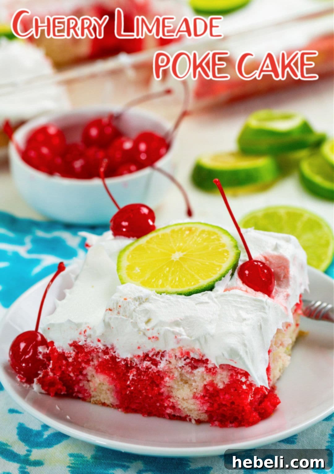 A close-up slice of Cherry Limeade Poke Cake garnished with a fresh lime slice and a maraschino cherry.