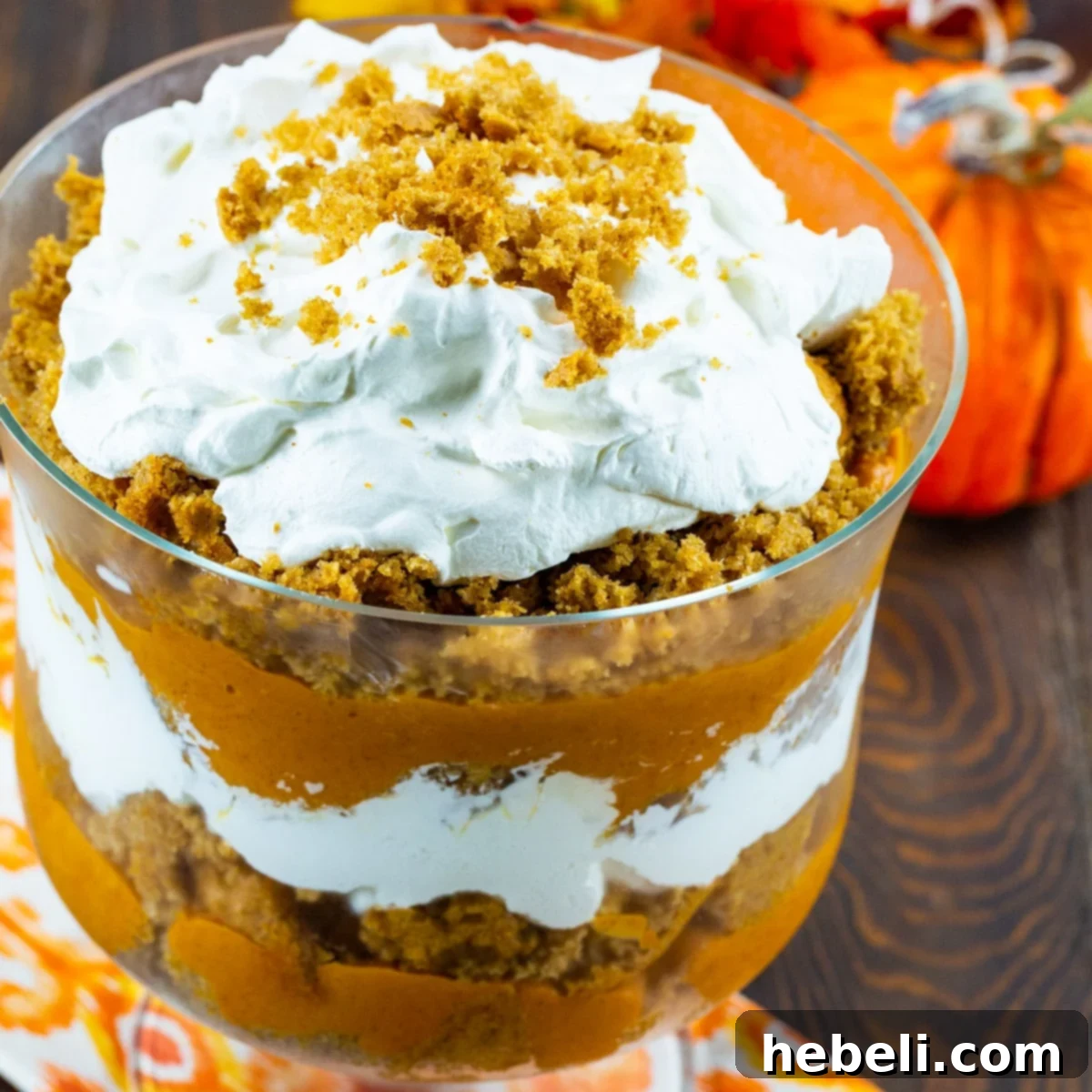 Autumn Butterscotch Pumpkin Trifle 2 Trifle topped with whipped cream in a trifle bowl, showcasing its beautiful layers.