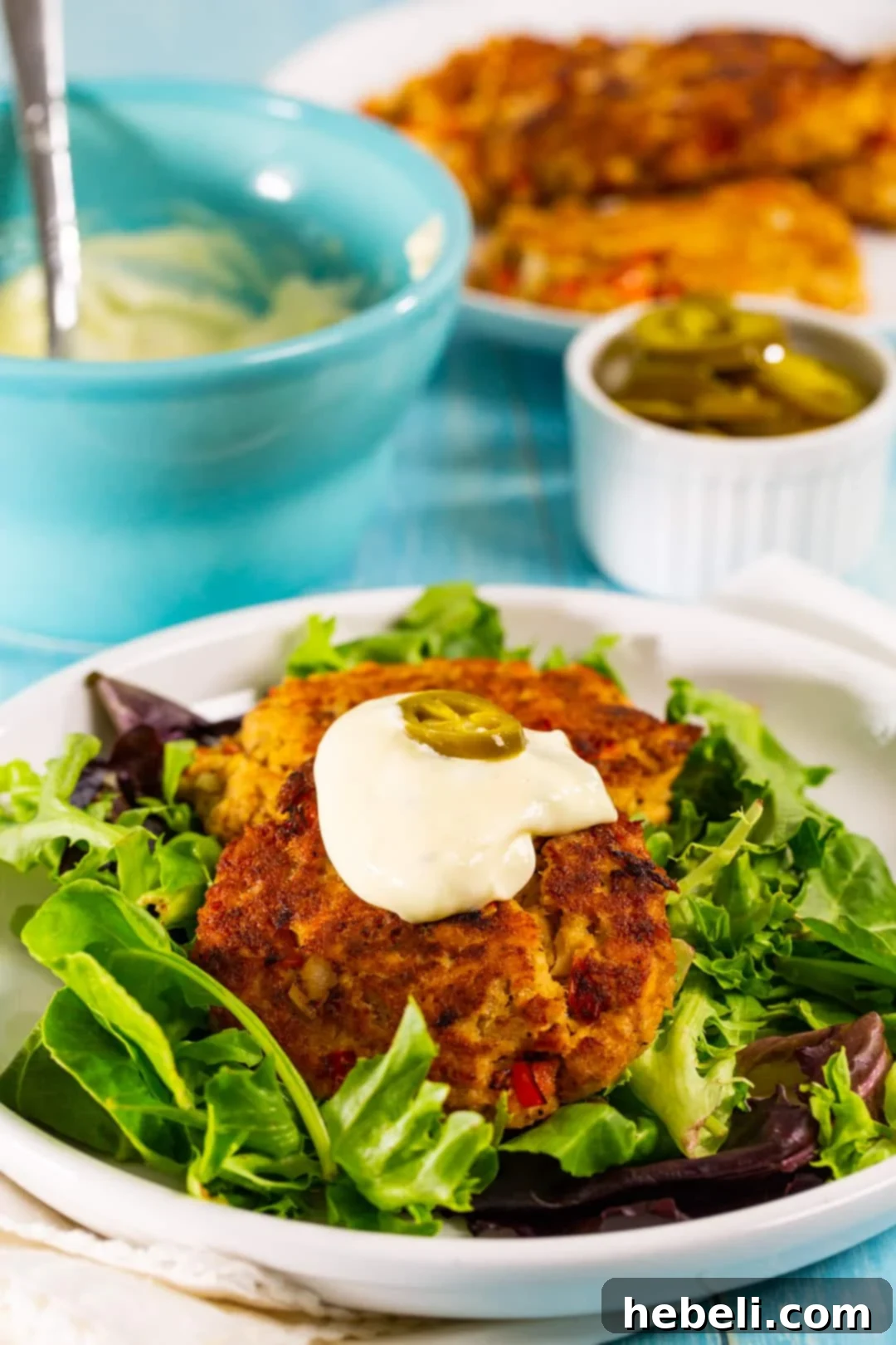 Zesty Bayou Salmon Fritters 4 Close-up of golden-brown salmon patties served on a bed of fresh mixed greens, ready to be enjoyed.