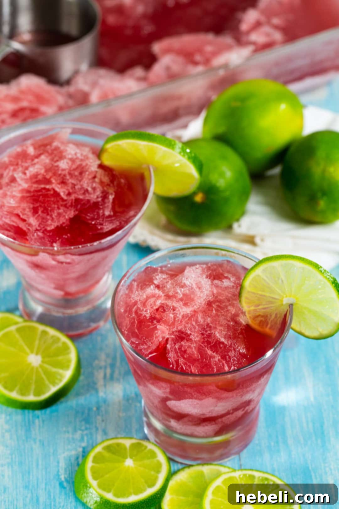 Two glasses of Cosmo Slush garnished with lime, ready to serve.