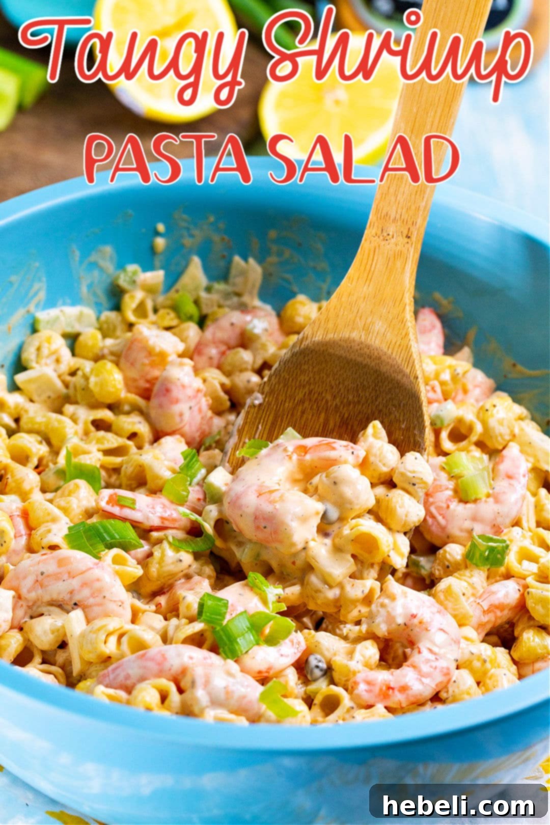 A wooden spoon scooping up a generous portion of Tangy Shrimp Pasta Salad from a large bowl.