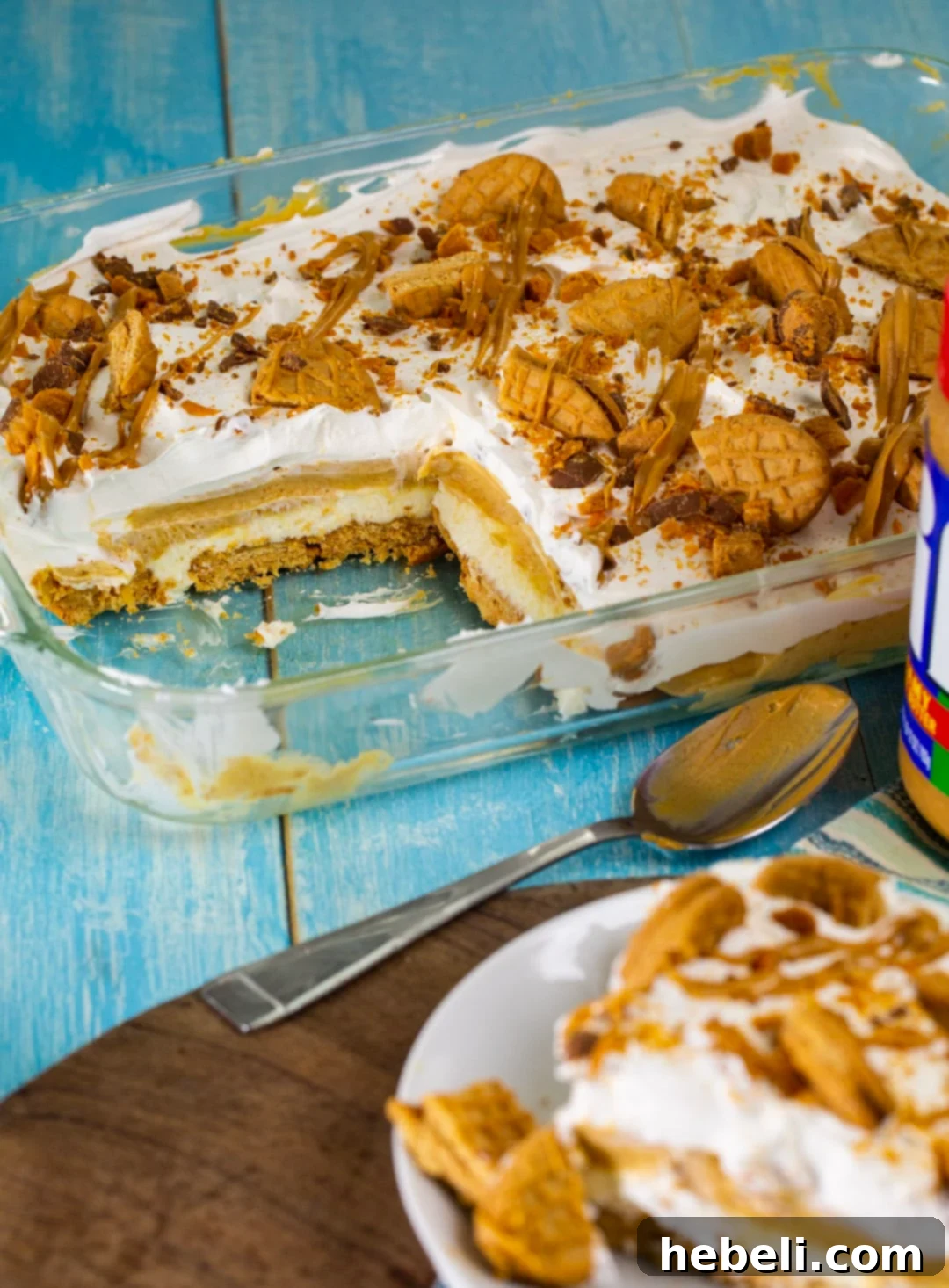Peanut Butter Lasagna in pan with a piece cut away, showing the layers.