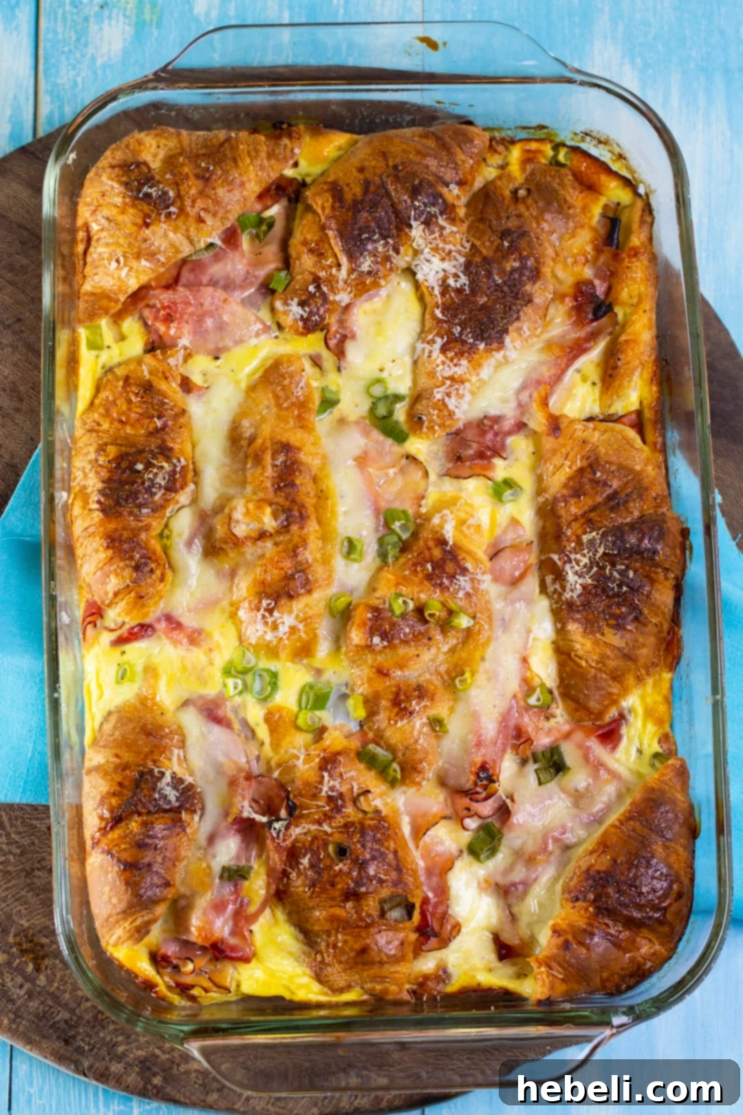 Savory Ham and Cheese Croissant Bake 3 The full Stuffed Ham and Cheese Croissant Casserole, beautifully baked to a golden perfection, resting in a glass baking dish, ready to be carved and served.