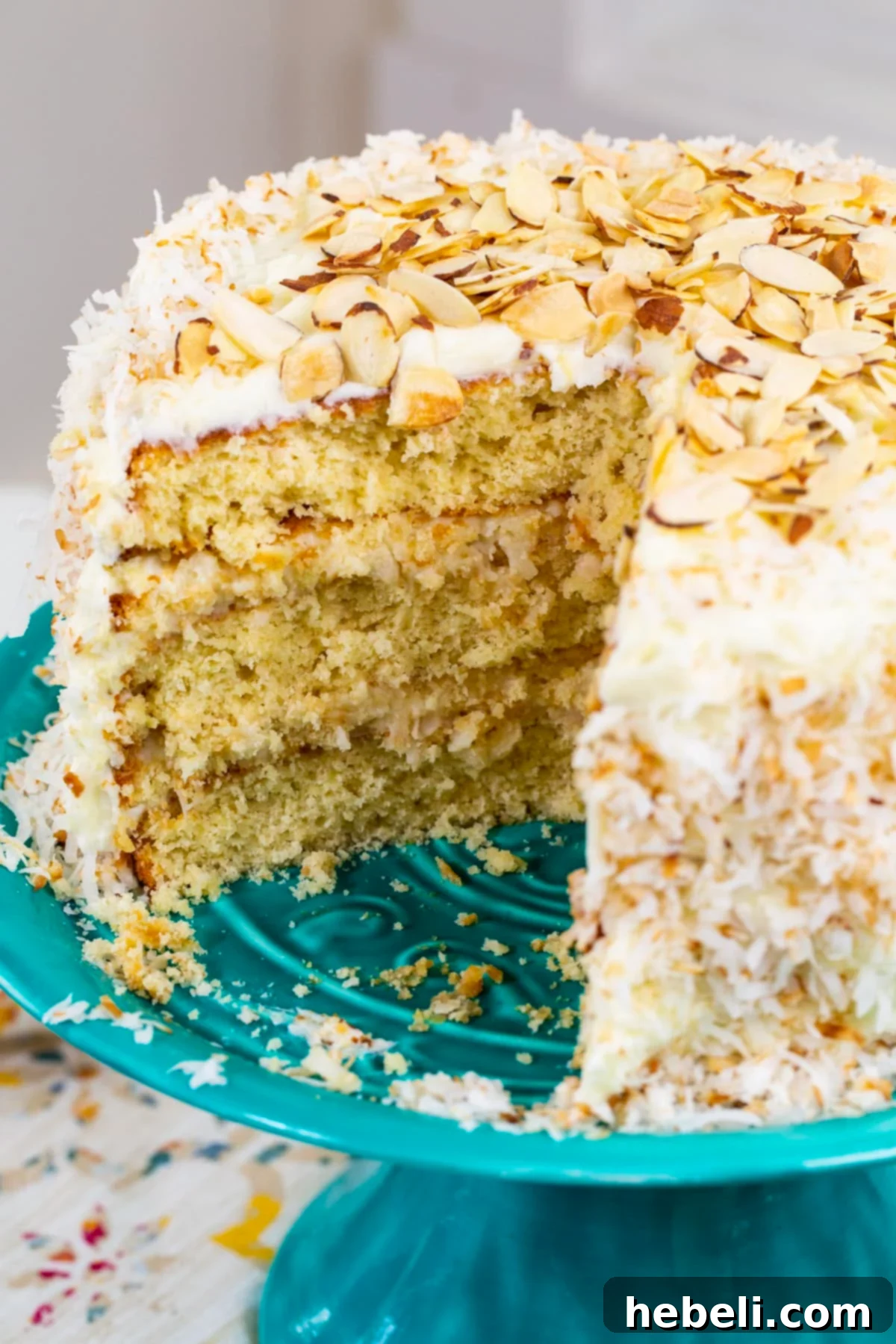 A generous slice of Coconut Almond Cream Cake on a plate, showcasing its moist texture and rich filling.