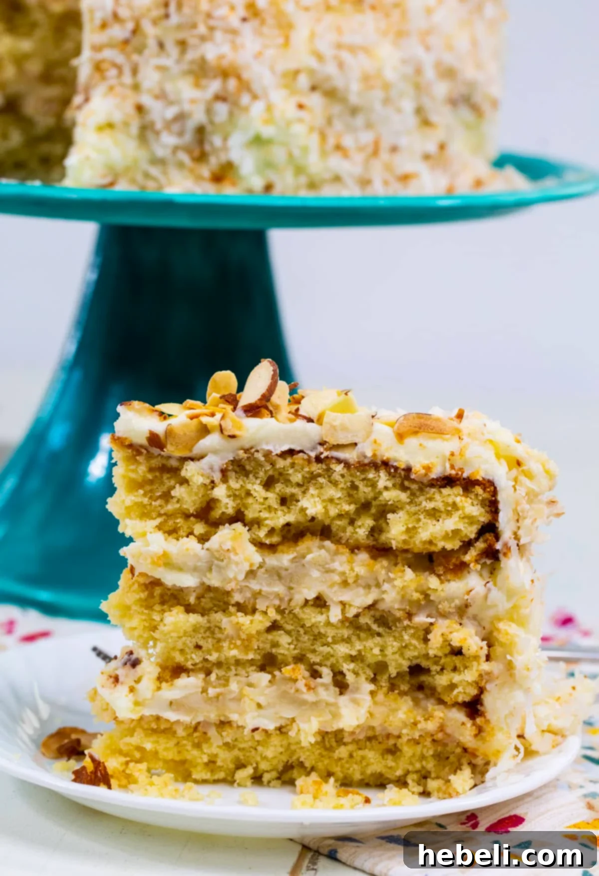 A single slice of Coconut Almond Cream Cake, perfectly plated and ready to be enjoyed.