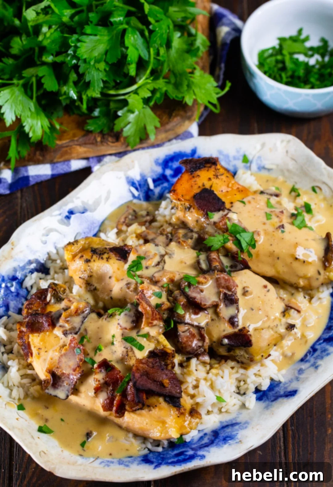A large serving platter showcasing slow cooker chicken with bacon gravy, garnished and ready to be served over rice.
