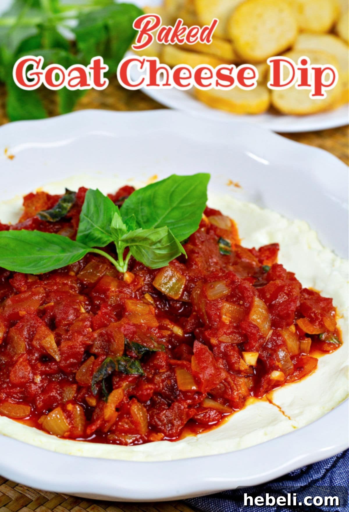 Baked Goat Cheese Dip garnished with fresh basil leaves.