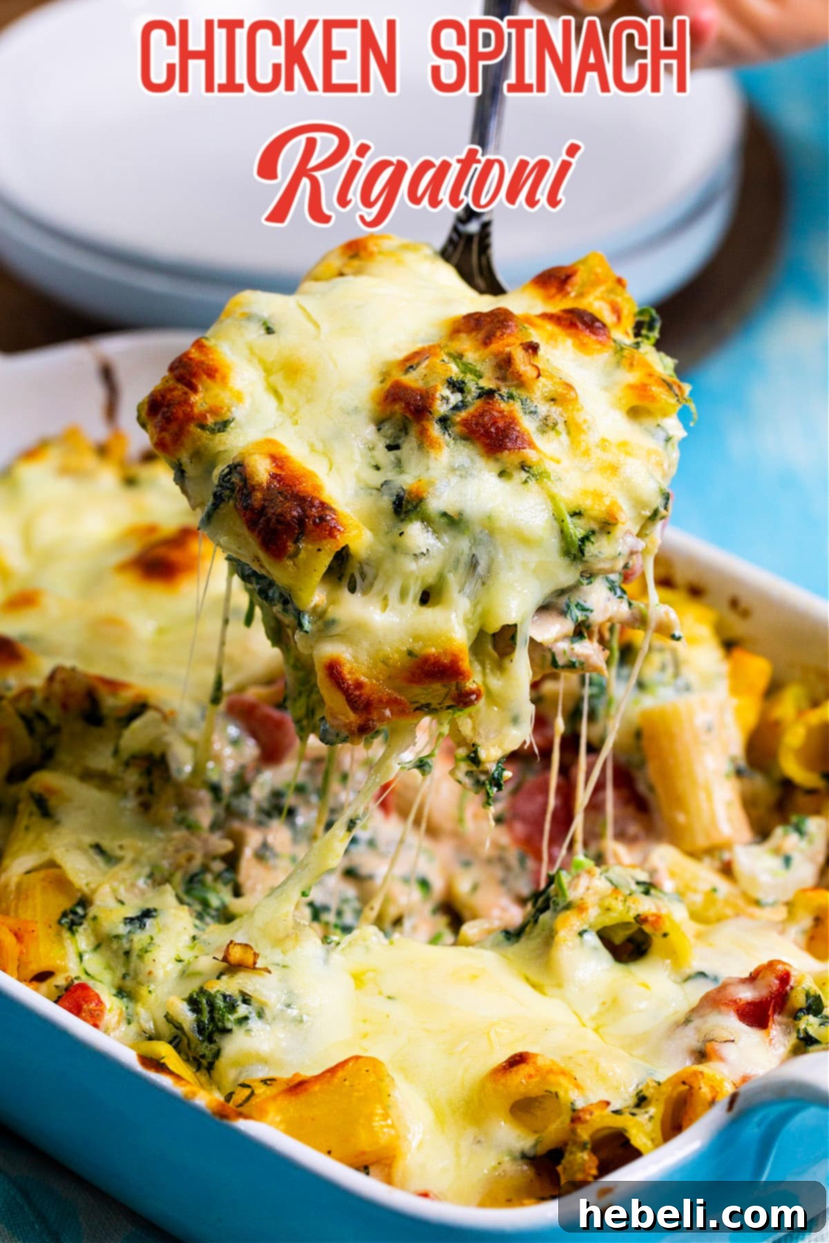 Spoon scooping up a portion of Chicken Spinach Rigatoni, highlighting the perfect pasta and creamy sauce.