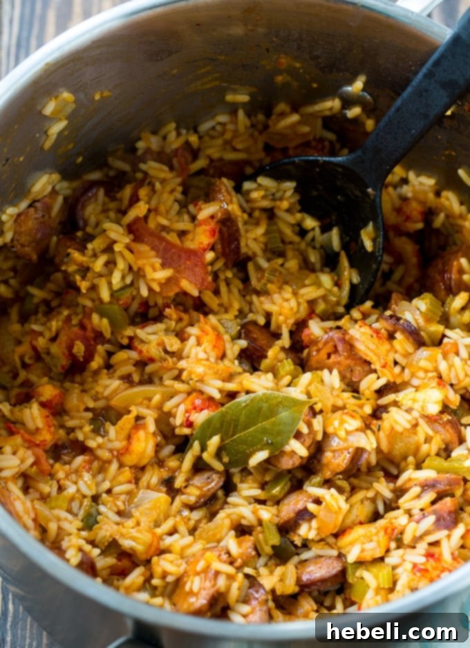 Close-up of Crawfish Jambalaya simmering in a Dutch oven, highlighting the textures of rice, sausage, and crawfish.