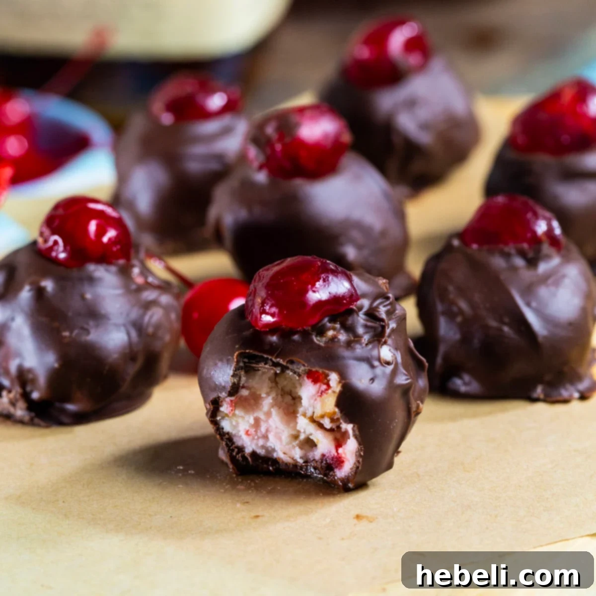 Delicious Cherry Bourbon Ball with a bite taken out, showcasing the rich, cherry-infused interior and chocolate coating.