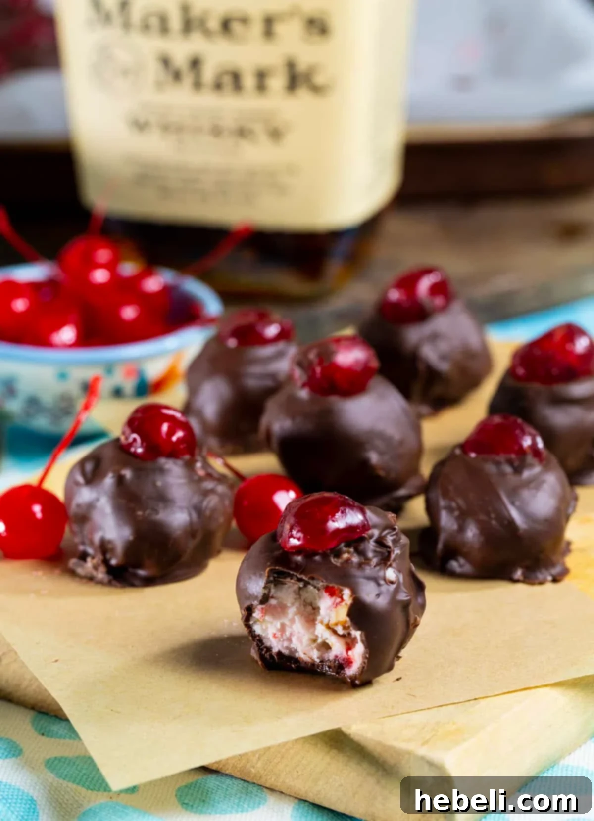 Detailed close-up of a Cherry Bourbon Ball with a bite missing, showing the texture of the pecan and cherry filling.
