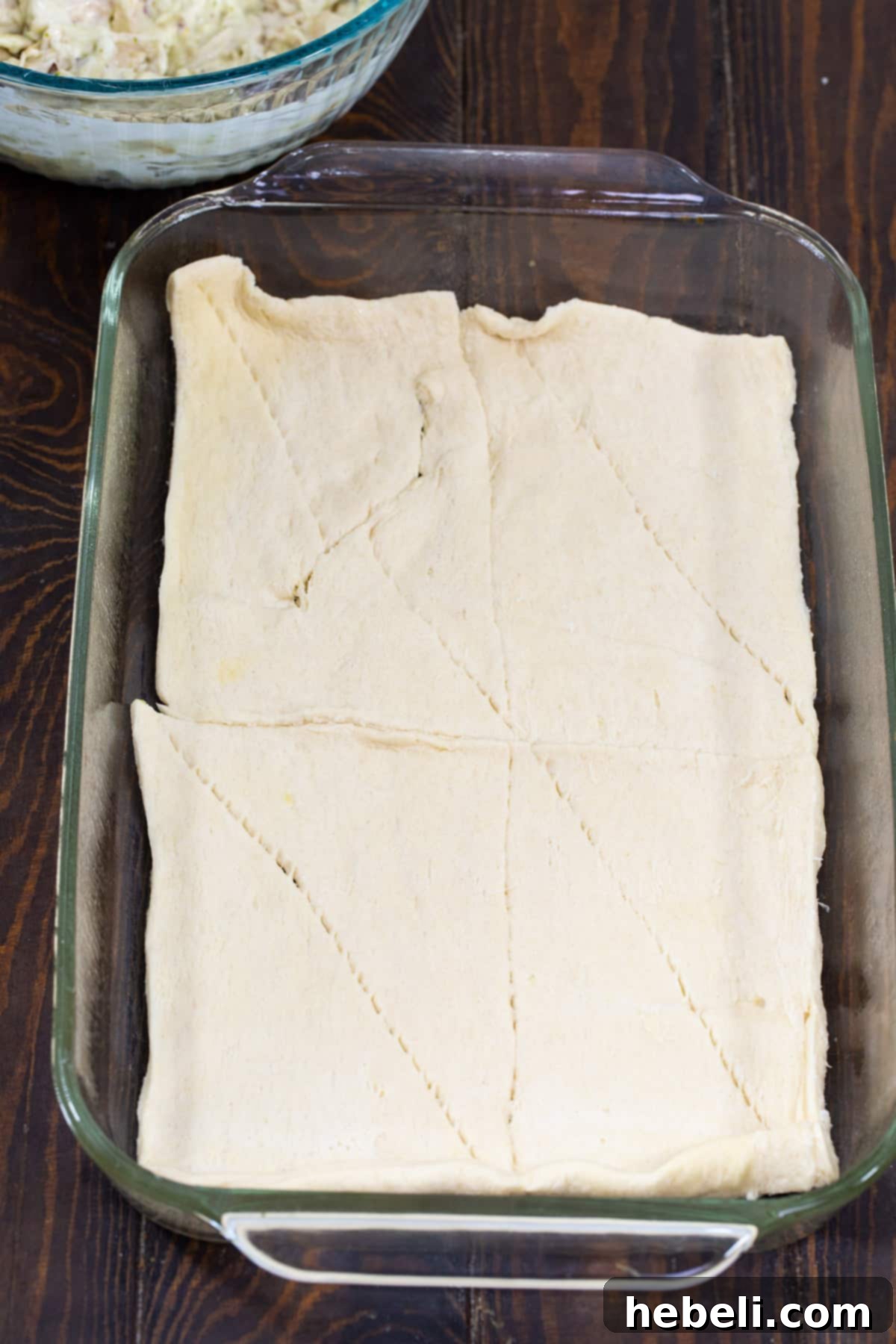 Cheesy Chicken Alfredo Crescent Rolls 4 Crescent dough perfectly spread in the bottom of a 9x13-inch baking pan, ready for the filling.
