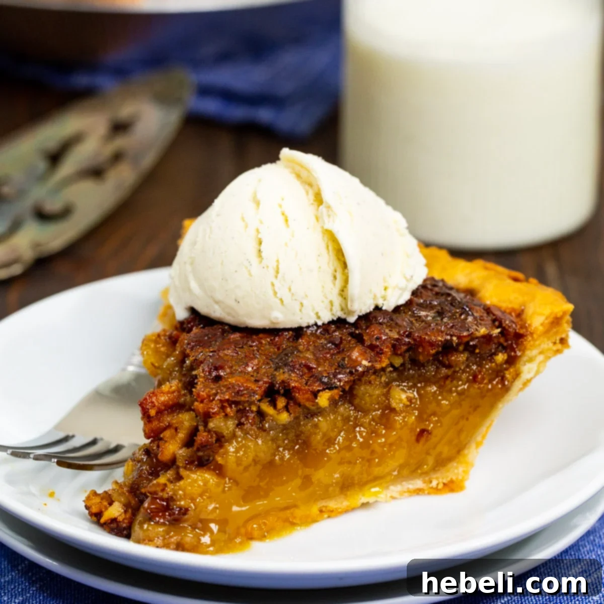 A delectable slice of Camellia Grill's pecan pie, perfectly topped with a scoop of melting vanilla ice cream, promising a harmonious blend of warm, gooey sweetness and cool, creamy delight.