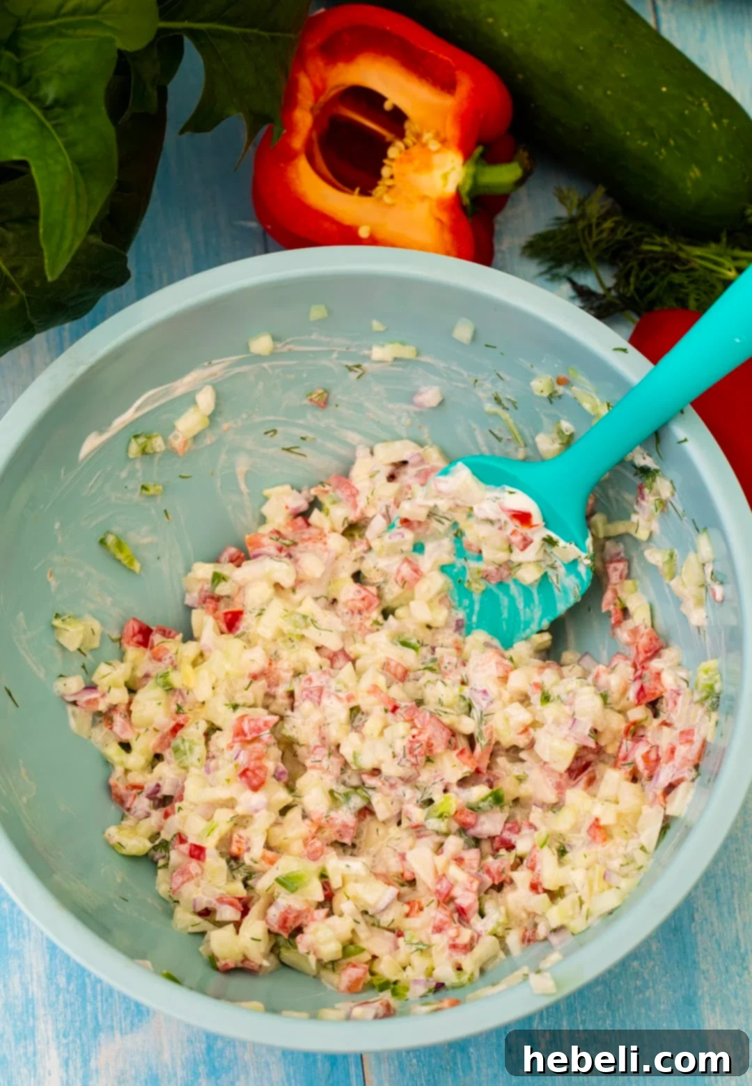 A close-up of Creamy Cucumber Salsa in a mixing bowl, showcasing its finely diced vegetables and creamy texture.