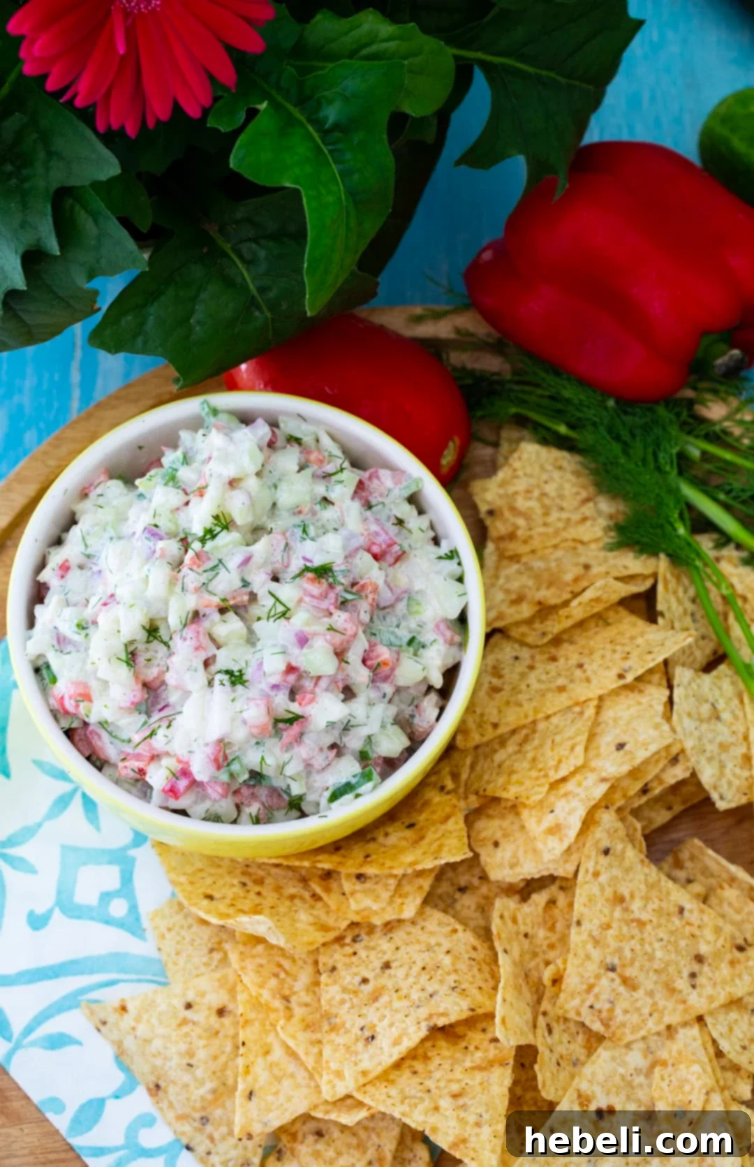 A bowl of Creamy Cucumber Salsa surrounded by golden tortilla chips, ready for serving at a summer gathering.