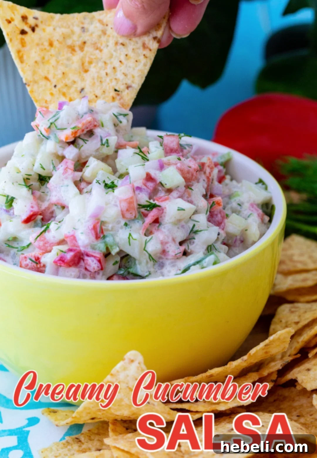 A close-up shot of a chip being dipped into the creamy cucumber salsa, emphasizing its appealing texture.