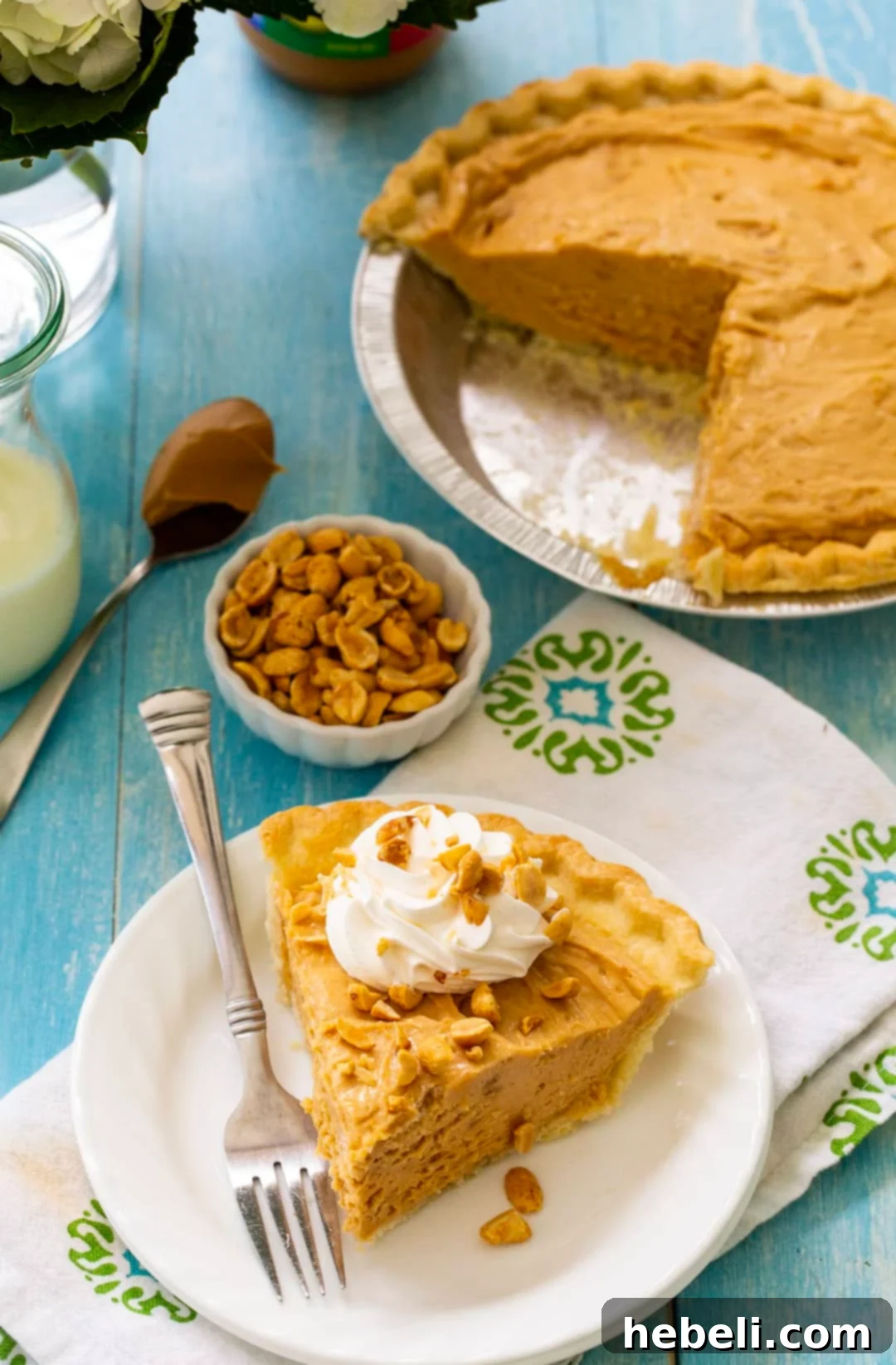 Homestyle Peanut Butter Pie 3 A close-up shot of a slice of Old-Fashioned Peanut Butter Pie on a plate, with the rest of the pie blurred in the background, showing the smooth, light brown filling and crisp crust.