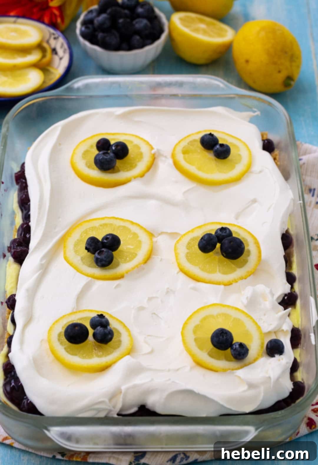 The Blueberry Lemon Layer Dessert displayed in a clear glass 9x13-inch baking dish, showing all the vibrant and distinct layers clearly before serving.
