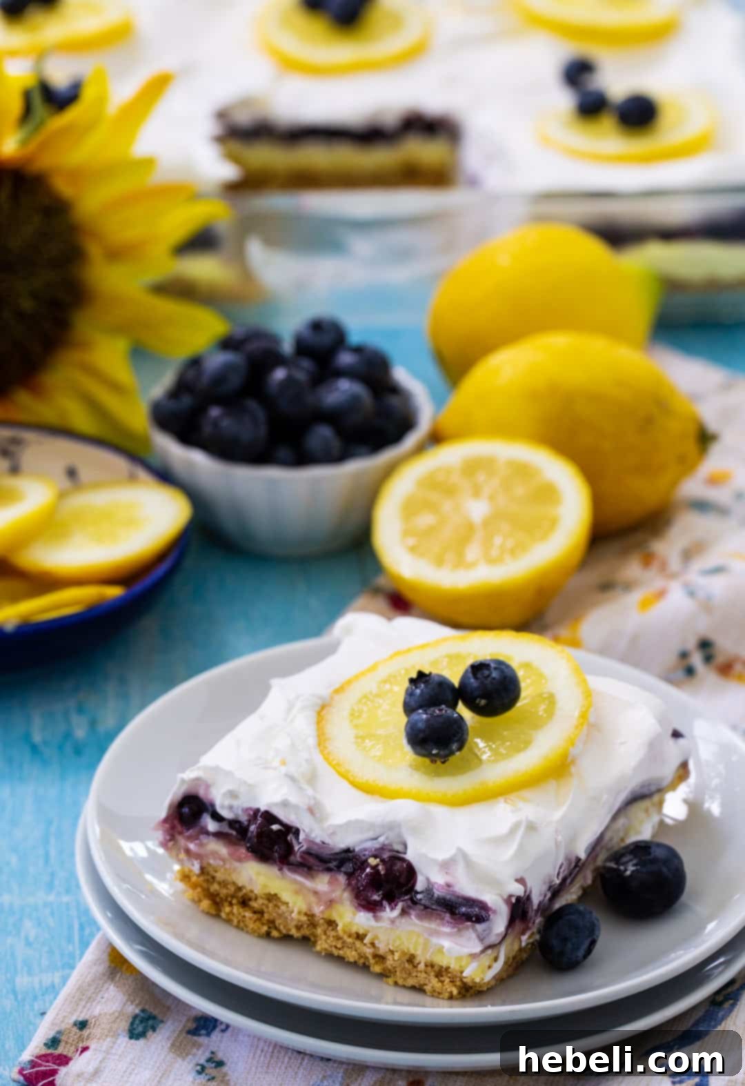 A single piece of Blueberry Lemon Layer Dessert on a small white plate, adorned with a fresh blueberry garnish, ready to be enjoyed as a refreshing treat.