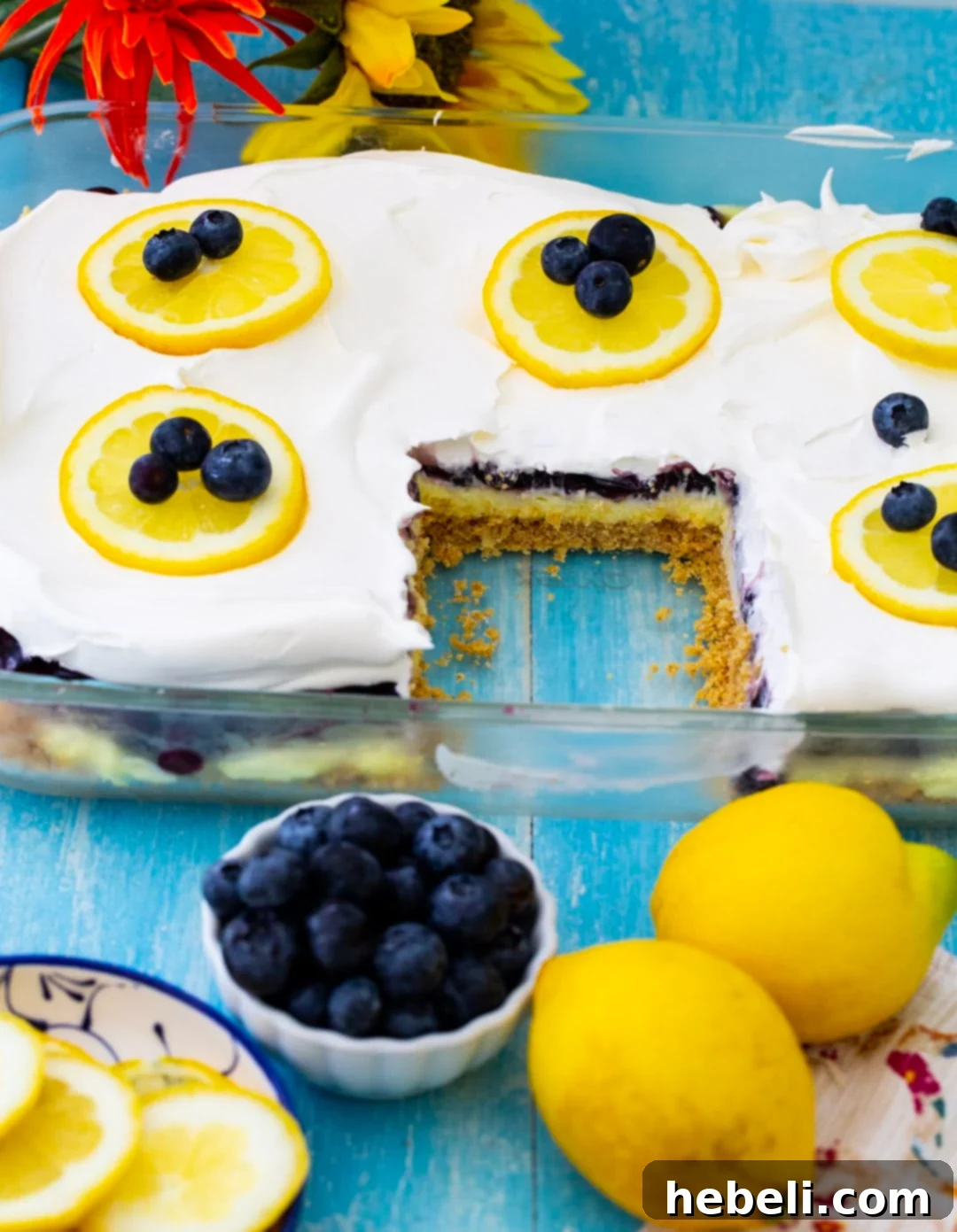 Blueberry Lemon Layer Dessert in a baking dish with one perfectly cut slice expertly removed, showcasing the clean, distinct layers and ready to be served.