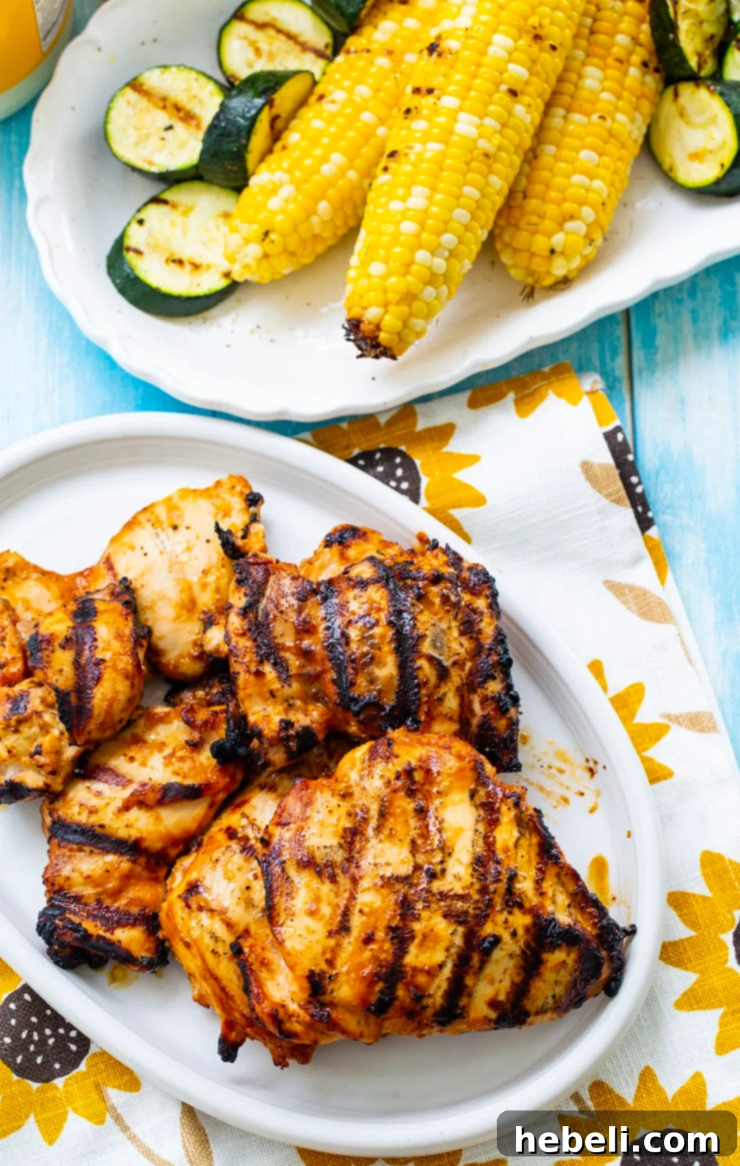 Smoky Tangy Grilled Chicken 3 A plate featuring perfectly grilled chicken alongside a vibrant array of grilled vegetables like corn and zucchini.