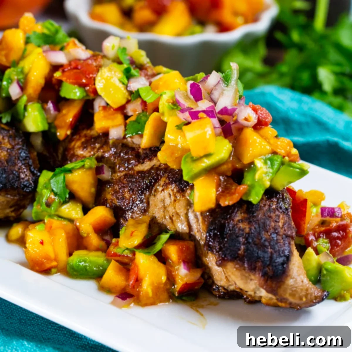 Seared Pork Tenderloin with Bright Nectarine Avocado Salsa 2 Pork Tenderloin with Nectarine Avocado Salsa on a serving plate, beautifully garnished with fresh herbs.