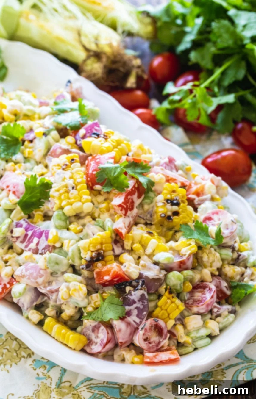 Charred Corn and Butter Bean Summer Medley 4 A beautifully arranged serving of Grilled Corn and Butter Bean Salad on a pristine white serving tray, garnished with fresh cilantro.
