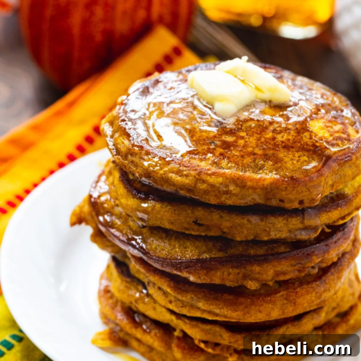 Maple Kissed Bourbon Vanilla Pumpkin Pancakes 2 Stack of golden pumpkin pancakes topped with a pat of melting butter and drizzled generously with amber bourbon vanilla maple syrup, ready to be enjoyed as a perfect fall breakfast.