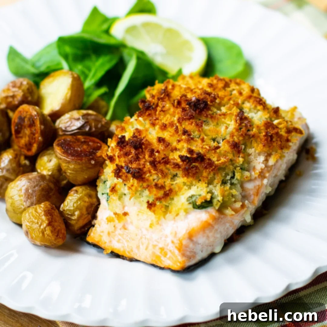 Baked Salmon Stuffed with Mascarpone Spinach on a plate with roasted potatoes, showcasing the rich filling and crispy topping.