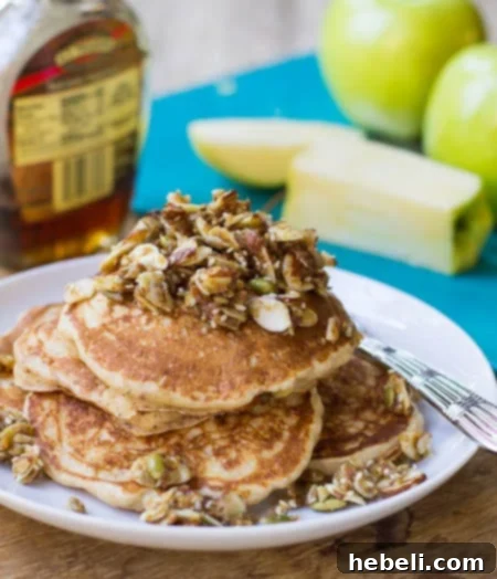 Whole Wheat Apple Pancakes on a plate with yellow apples in background.