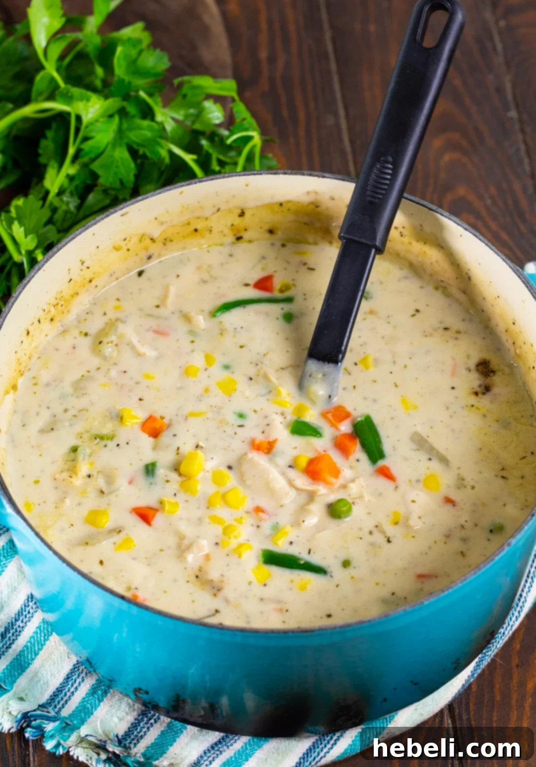 Hearty Chicken Pot Pie Soup 3 Rich and creamy Chicken Pot Pie Soup simmering gently in a large, elegant Dutch oven, showcasing its abundant chicken and vegetable ingredients.