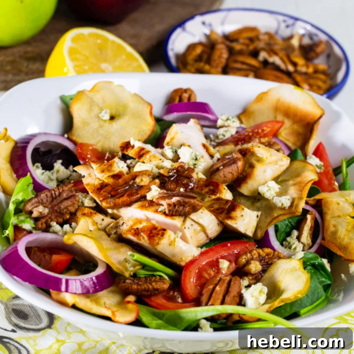 Fuji Mountain Chicken Medley 2 A vibrant bowl of homemade Fuji Apple Chicken Salad, showcasing tender chicken, fresh greens, red onions, and apple chips.