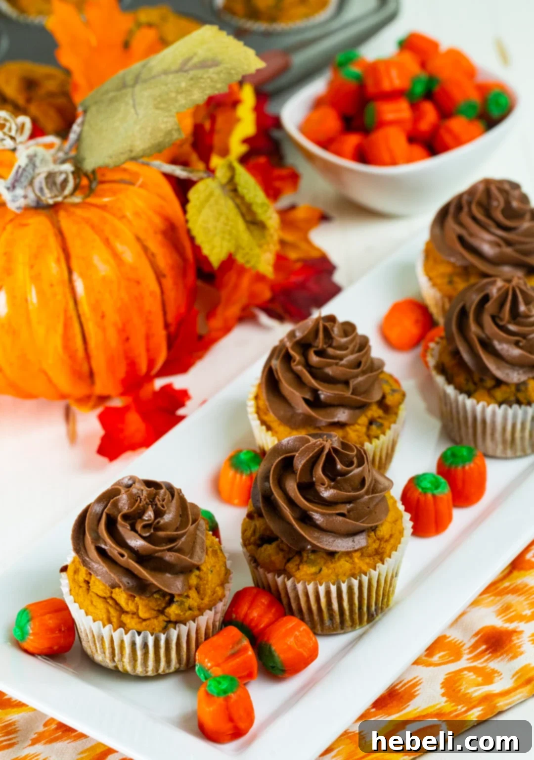 A charming display of frosted pumpkin chocolate chip cupcakes arranged neatly on a serving tray, ready to be enjoyed.