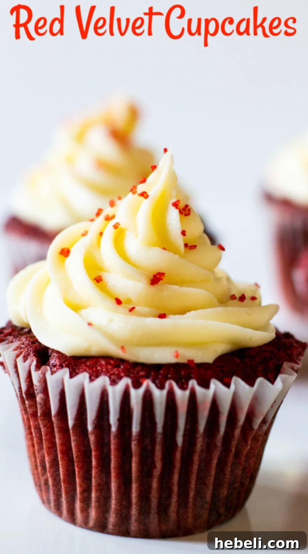 A beautiful array of Red Velvet Cupcakes, each perfectly frosted with creamy white icing and adorned with vibrant red sprinkles, inviting a delicious indulgence.
