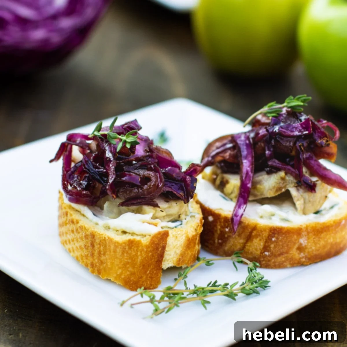 Two pieces of Pork Tenderloin Crostini with Sweet- and Sour Cabbage on a plate, ready to be served as an appetizer.
