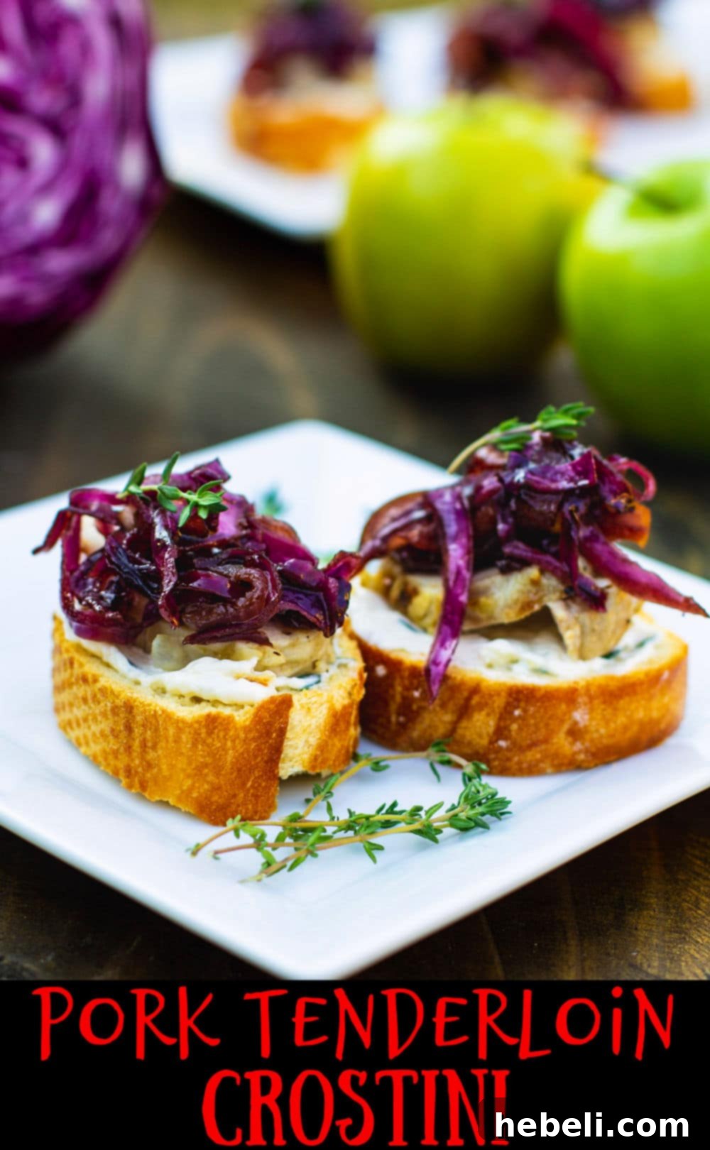 A close-up of a finished Pork Tenderloin Crostini with Sweet- and Sour Cabbage, garnished with fresh thyme, on a white plate.