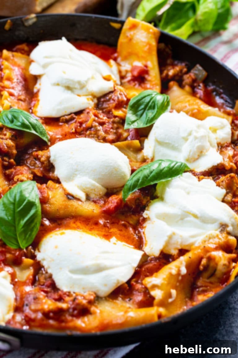 A vibrant close-up of Easy Skillet Lasagna, showcasing melted cheese, sausage, and basil, ready in under 45 minutes.
