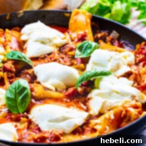 Skillet Lasagna in skillet topped with fresh basil.