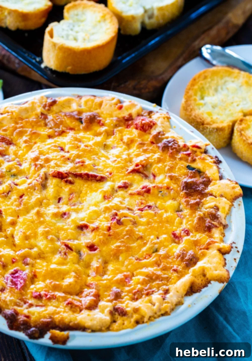 Bubbly Baked Pimento Cheese Dip 3 Pimento Cheese Dip bubbling hot in a rustic pie plate, garnished with fresh herbs.